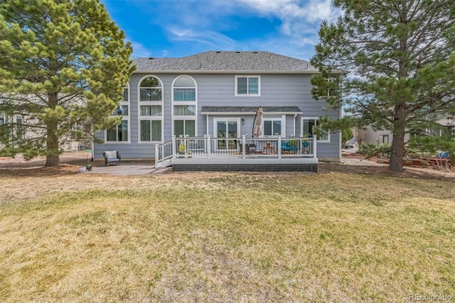 back of house with a wooden deck, a yard, and a patio