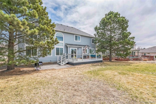 rear view of property with a yard, a patio area, and a deck
