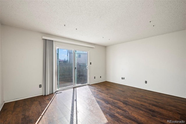 empty room with a textured ceiling and hardwood / wood-style floors