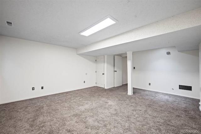 basement featuring a textured ceiling and carpet