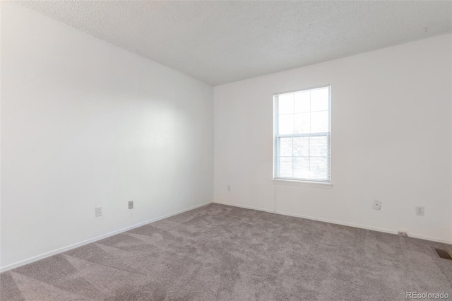 carpeted spare room featuring a textured ceiling