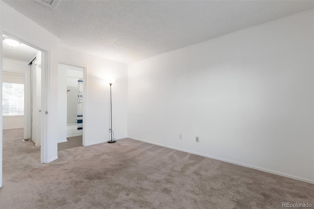 unfurnished bedroom with a textured ceiling and light colored carpet