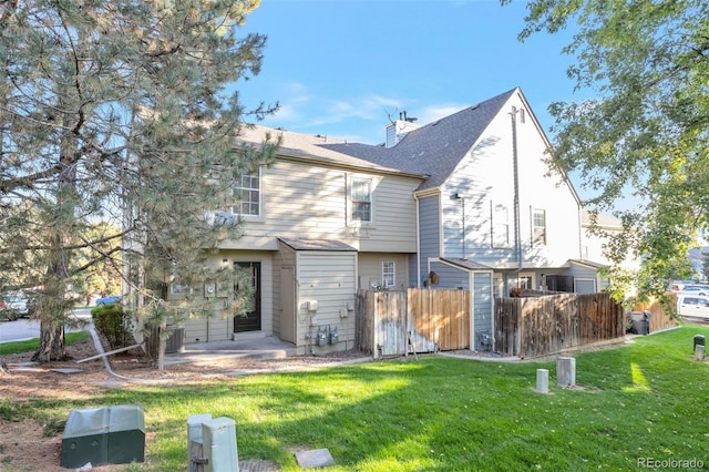 back of house with a yard and central AC unit