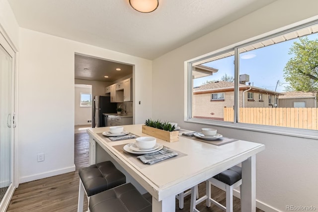 3871 Moore St, Wheat Ridge, CO 80033 - dining room with dark wood-type flooring, healthy amount of natural light, and baseboards