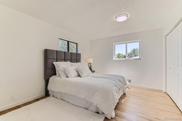 3871 Moore St, Wheat Ridge, CO 80033 - bedroom with baseboards, light wood-style flooring, and a closet