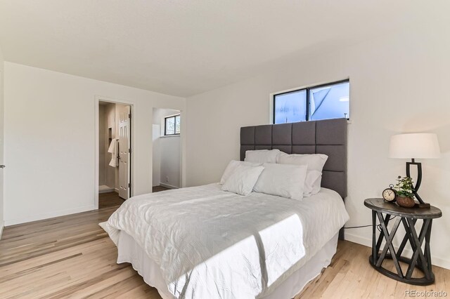 3871 Moore St, Wheat Ridge, CO 80033 - bedroom with multiple windows, light wood-style floors, and baseboards