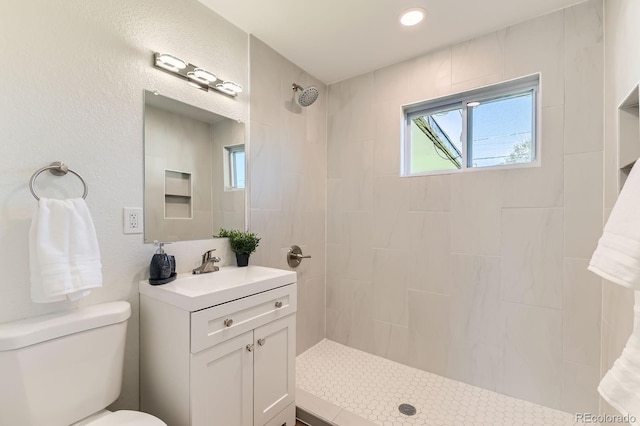 3871 Moore St, Wheat Ridge, CO 80033 - full bathroom featuring tiled shower, toilet, plenty of natural light, vanity, and recessed lighting