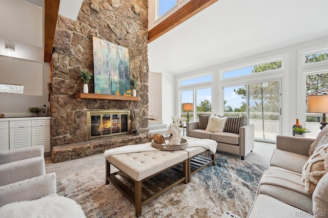 living room with high vaulted ceiling, a fireplace, a healthy amount of sunlight, and beam ceiling