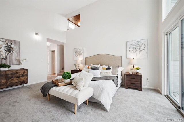 carpeted bedroom featuring a high ceiling