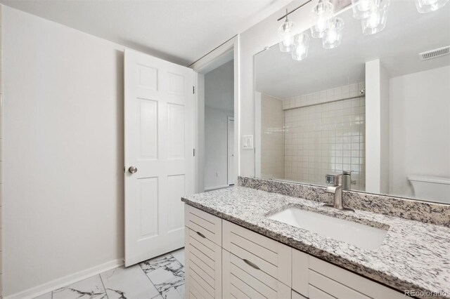 bathroom featuring vanity, tile patterned flooring, and toilet