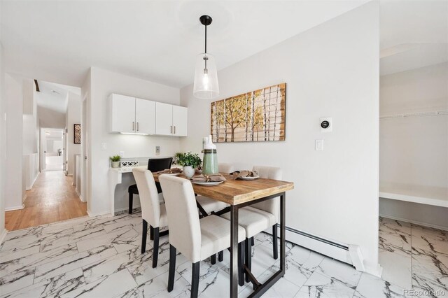 dining room with lofted ceiling, a baseboard heating unit, and light hardwood / wood-style flooring