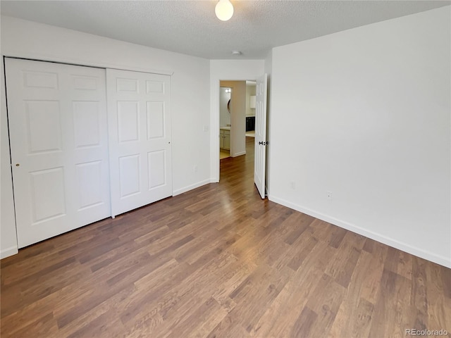 5966 S Winnipeg St, Aurora, CO 80015 - unfurnished bedroom featuring wood finished floors, a textured ceiling, and a closet