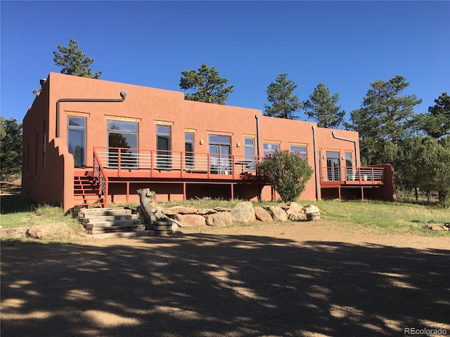 rear view of house with a wooden deck