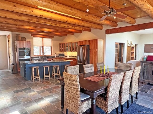 dining space with dark tile floors, ceiling fan, wooden ceiling, beamed ceiling, and sink