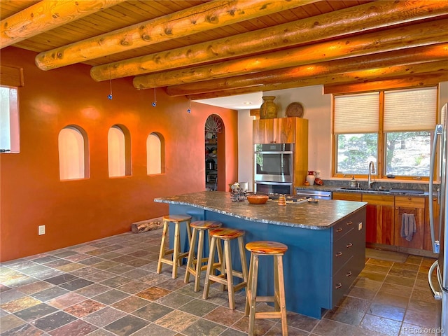 kitchen with dark tile floors, a kitchen island, wooden ceiling, a kitchen bar, and stainless steel double oven