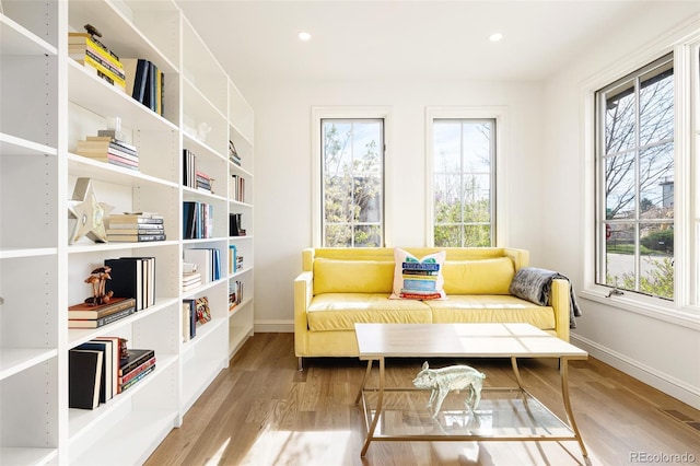 sitting room featuring wood finished floors, baseboards, and a healthy amount of sunlight