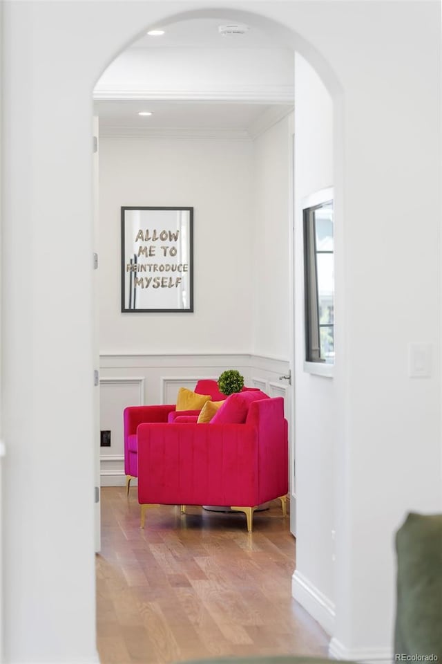 interior space featuring crown molding, arched walkways, and wood finished floors