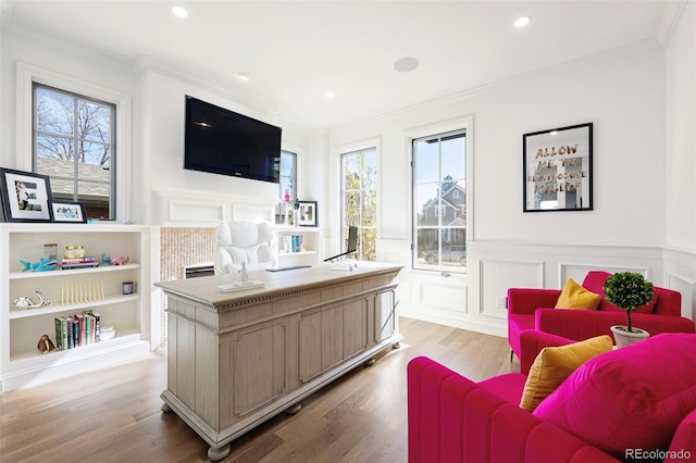 office space with ornamental molding, a healthy amount of sunlight, a decorative wall, and wood finished floors