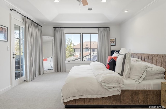 bedroom with a tray ceiling, visible vents, carpet floors, and access to exterior