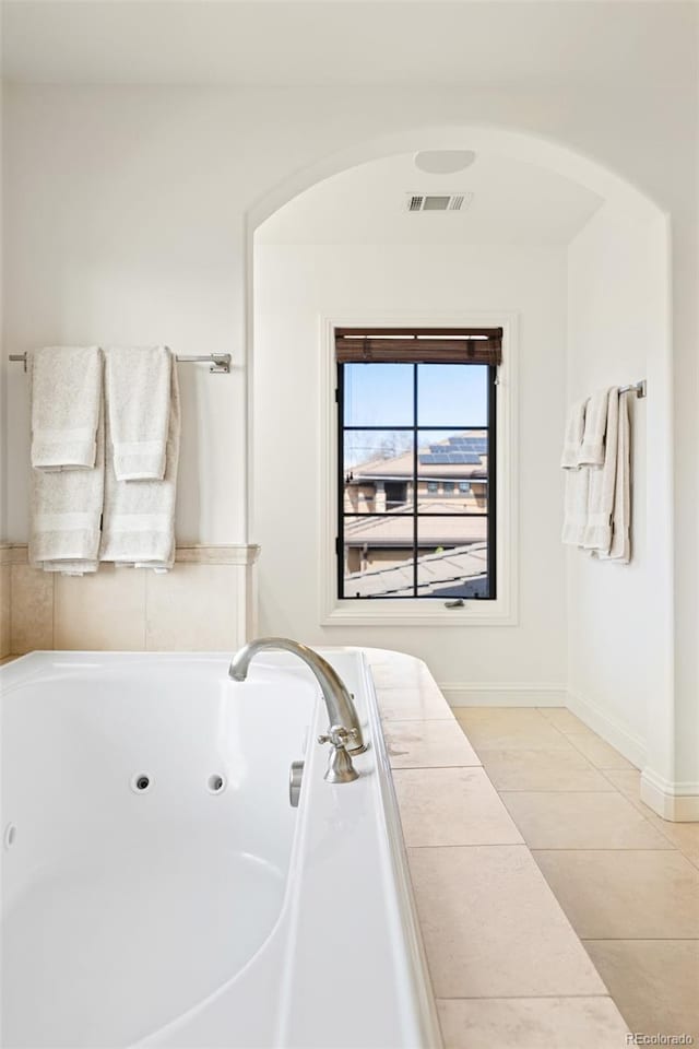 bathroom with baseboards, tile patterned floors, visible vents, and a whirlpool tub
