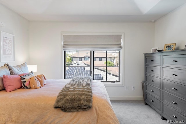 bedroom with light colored carpet and baseboards