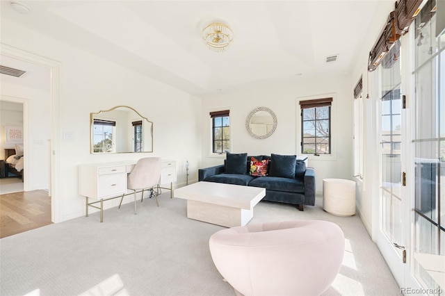 carpeted living room featuring visible vents and baseboards