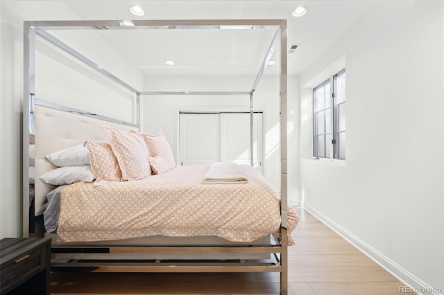 bedroom featuring baseboards, light wood-type flooring, visible vents, and recessed lighting