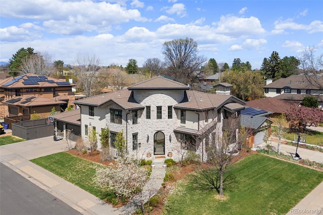mediterranean / spanish home featuring concrete driveway, a garage, stone siding, and a front yard