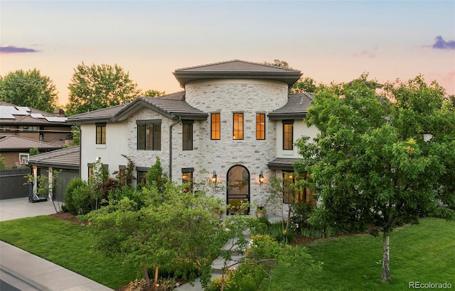 5455 E Cedar Ave, Denver, CO 80246 - view of front of home featuring stone siding, a yard, a tiled roof, and concrete driveway