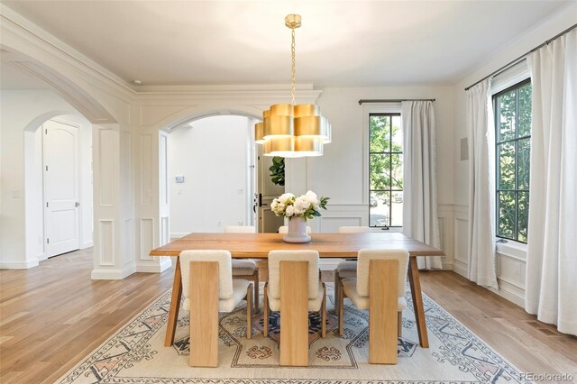 5455 E Cedar Ave, Denver, CO 80246 - dining room featuring arched walkways, light wood-type flooring, and a decorative wall