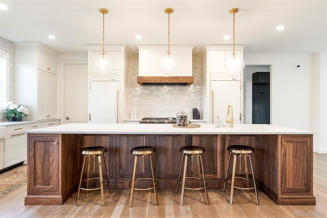5455 E Cedar Ave, Denver, CO 80246 - kitchen featuring light wood-type flooring, backsplash, light countertops, a spacious island, and recessed lighting