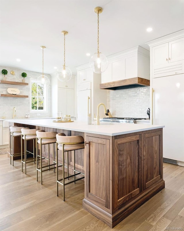 5455 E Cedar Ave, Denver, CO 80246 - kitchen with paneled refrigerator, tasteful backsplash, light countertops, light wood-style floors, and recessed lighting