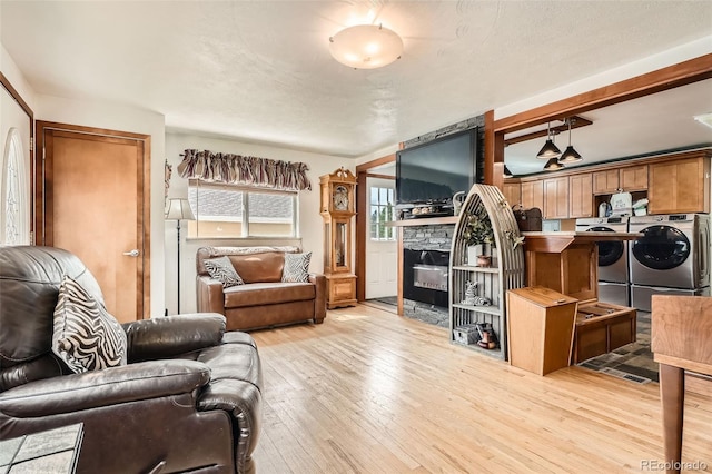 15325 W 32nd Ave, Golden, CO 80401 - living room featuring washer and dryer, light wood finished floors, and a fireplace