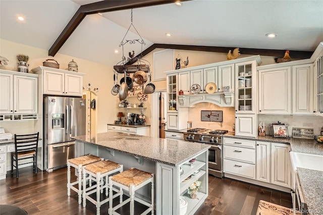 15325 W 32nd Ave, Golden, CO 80401 - kitchen with light stone counters, a kitchen island, lofted ceiling with beams, appliances with stainless steel finishes, and dark wood-style floors