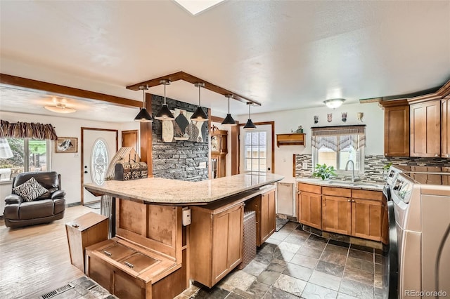 15325 W 32nd Ave, Golden, CO 80401 - kitchen with washer and dryer, tasteful backsplash, open floor plan, a sink, and beam ceiling