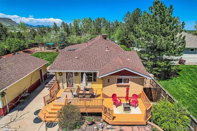 15325 W 32nd Ave, Golden, CO 80401 - rear view of house featuring roof with shingles, a fenced backyard, a wooden deck, brick siding, and outdoor dining area