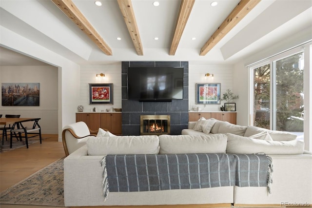 living room with beamed ceiling, hardwood / wood-style floors, and a fireplace