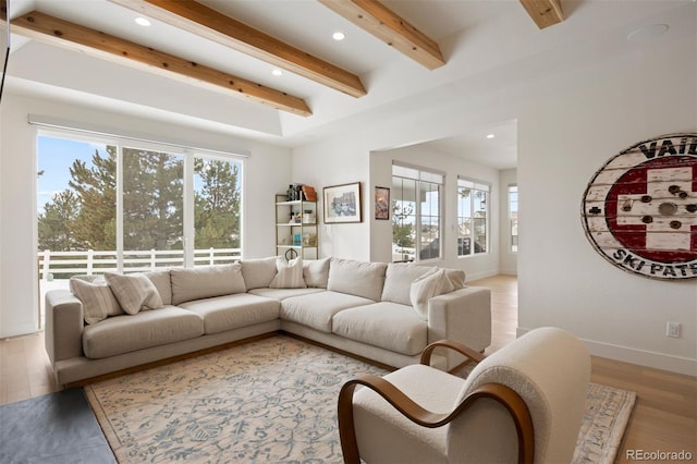 living room featuring beamed ceiling and light wood-type flooring