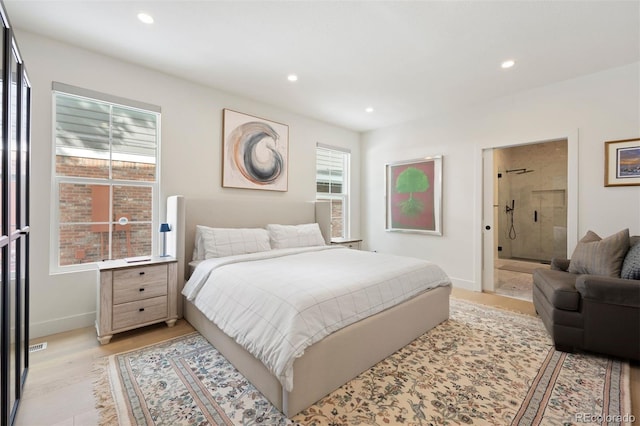 bedroom featuring ensuite bathroom and light wood-type flooring