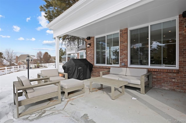 snow covered patio featuring an outdoor living space and grilling area