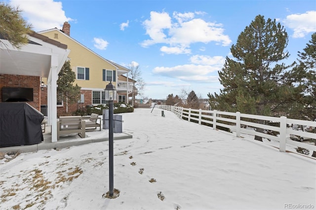 snowy yard featuring a balcony