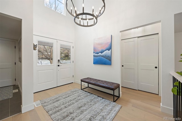 entrance foyer with an inviting chandelier and light hardwood / wood-style flooring