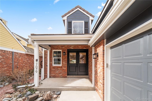 view of exterior entry featuring french doors and covered porch