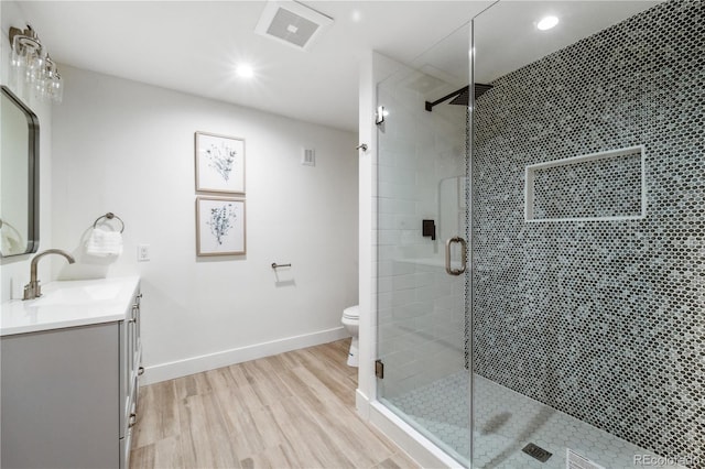 bathroom featuring vanity, hardwood / wood-style flooring, toilet, and walk in shower