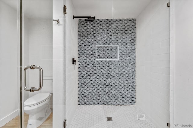 bathroom with toilet and a shower with shower door