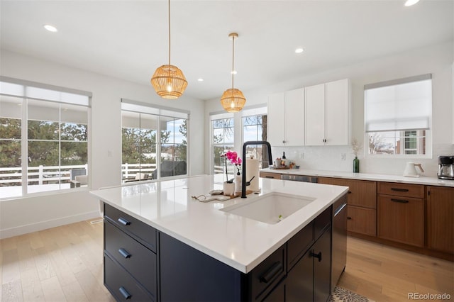 7079 S Locust Pl, Centennial, CO 80112 - kitchen featuring light countertops, recessed lighting, a sink, and light wood-style flooring