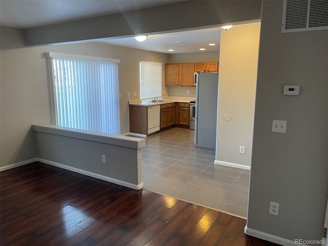 kitchen with dishwasher, hardwood / wood-style floors, stainless steel refrigerator, range with electric cooktop, and sink