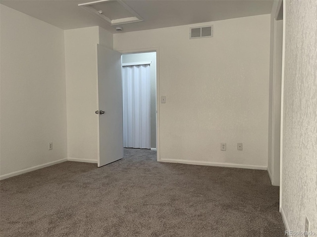 spare room featuring dark colored carpet