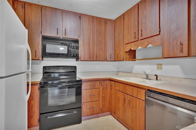 kitchen with a sink, black appliances, and light countertops