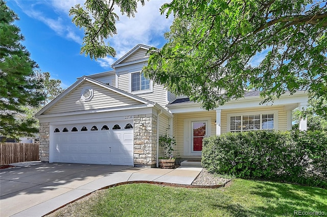 view of property featuring a front yard and a garage